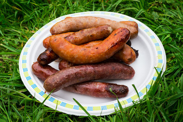 Chargrilled sausages piled on a plate.