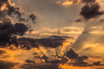 Fototapeta na wymiar sun rays on dark clouds sunset