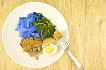 Eating blue rice noodle gravy vegetarian with fork wood