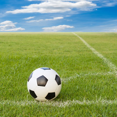 Fototapeta premium soccer ball on soccer field against blue sky