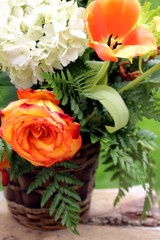 Basket of flower, rose and hydrangea on a wooden board