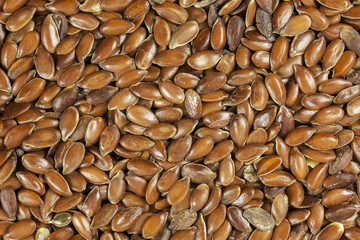Brown flax seeds background, close up.
