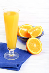 Glass of orange juice  on a light wooden background