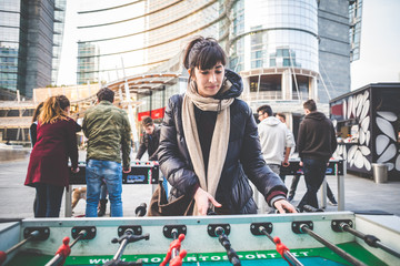 young beautiful hipster woman playing table football