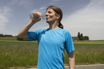 Jogger man refreshing during workout outdoors