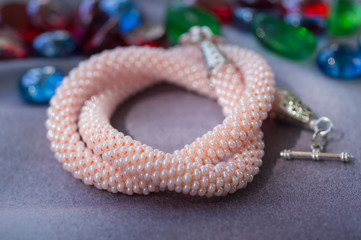 Knitted necklace from beads of pink color