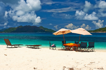 Tropical beach at Seychelles with picnic table and chairs