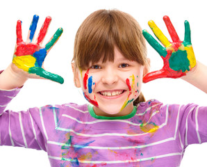 Portrait of a cute girl playing with paints