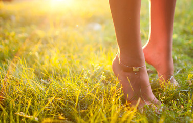 Female legs in summer grass in the sun