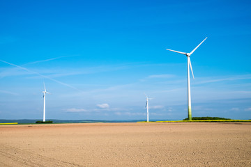 Windwheels behind a barren field