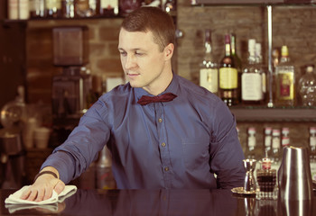 young man working as a bartender in a nightclub bar