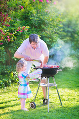 Father and daughter grilling in the garden