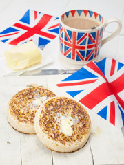 Buttered English crumpets with cup of tea and flag in closeup