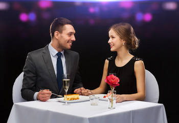 smiling couple eating dessert at restaurant