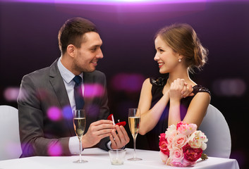 man proposing to his girlfriend at restaurant