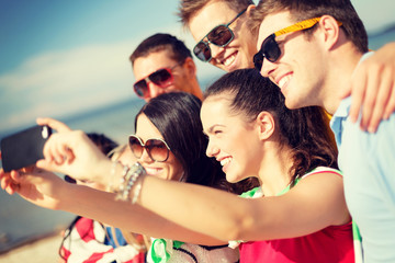 group of friends taking picture with smartphone