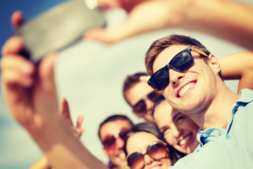 group of friends taking picture with smartphone