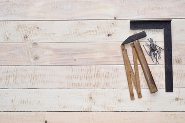 Carpenter tools - hammer, nails, tape measure on wood