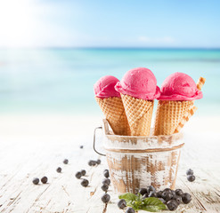 Ice cream scoops in cones with blur beach