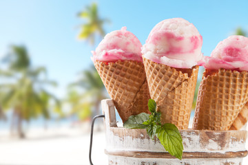 Ice cream scoops in cones with blur beach