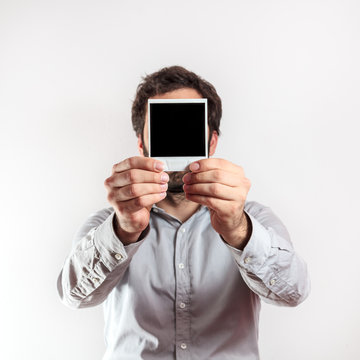 young man with empty photo frame i over the face