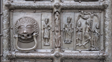 Door knocker and bas-relief of ancient bronze gate