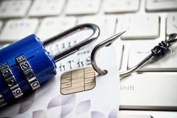 fish hook with a credit card and security lock on keyboard
