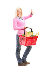 Young girl holding a shopping basket full of groceries