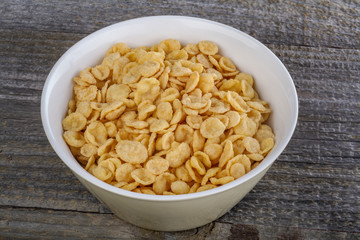 .closeup cornflakes in a bowl on a rustic table
