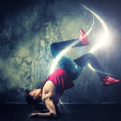 Stylish  break-dancer dancing with magic beams around him