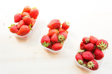 strawberry fruits in plastic pack on wooden table