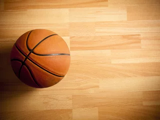 Fototapeten An official orange ball on a hardwood basketball court © Wouter Tolenaars