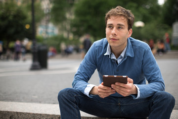 Obraz premium Young caucasian man reading tablet pc computer ebook