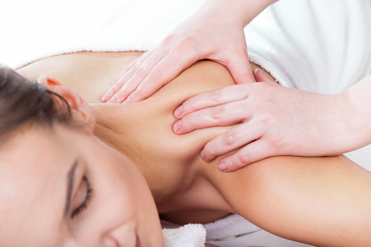 Hands massaging female neck