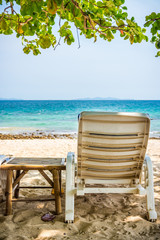 Beach chair and side table are on sand beach