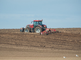 Obraz premium Tractor ploughing agricultural land