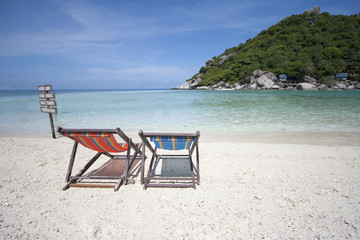 Deck chairs on white sand beach