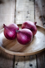 Red onion in wooden plate