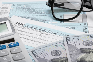 USA Tax Form 1040 with calculator, dollars and glasses