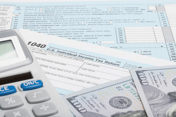 Fototapeta na wymiar US Tax Form 1040 with calculator and US dollars