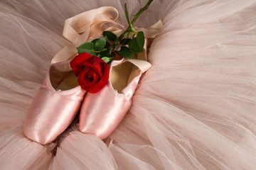 Old used ballet slippers lying on floor with rose and tutu © Alta Oosthuizen