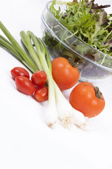 Salad, tomatoes, spring onions and orange pepper isolated on whi