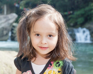 Young girl in front of waterfall