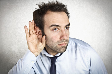 Businessman holding a hand to his ear