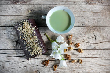 Chocolate swiss roll with walnuts and cup of green tea