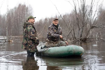 Papier Peint photo Lavable Chasser the hunters put stuffed ducks on water from a rubber boat
