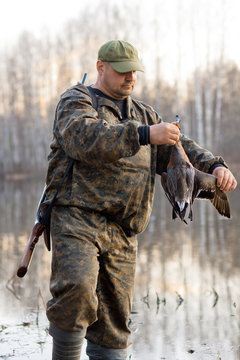 hunter holds a dead duck