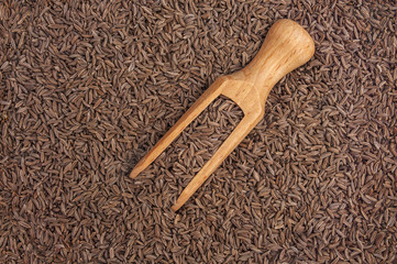 Cumin seeds macro and wooden spoon as background