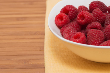 Fresh raspberries in a round white plate