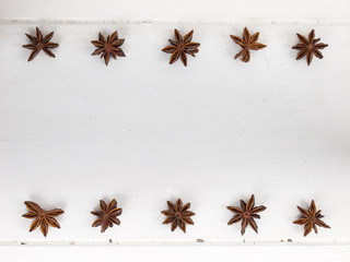 rows of star anise  on a rustic white table top